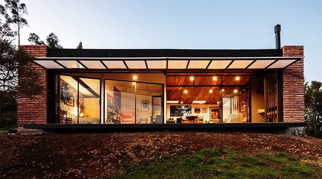 Modern glass house with sleek architectural design, large windows, and open interior layout showcasing contemporary architecture and stylish home decor.