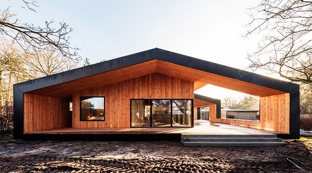 Contemporary wooden house with modern architectural design, large glass windows, and sleek lines, blending seamlessly with natural surroundings.