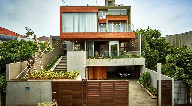 Modern contemporary house with sleek design, large glass windows, and a mix of wood and concrete materials showcasing luxury architecture and innovative home design.