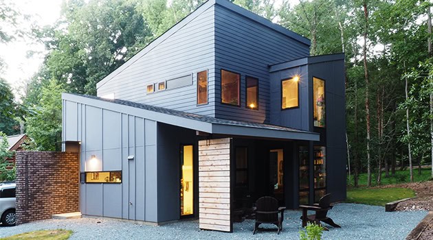 Contemporary modern house with sleek exterior design, minimalist architecture, and clean lines, located in a lush green environment.