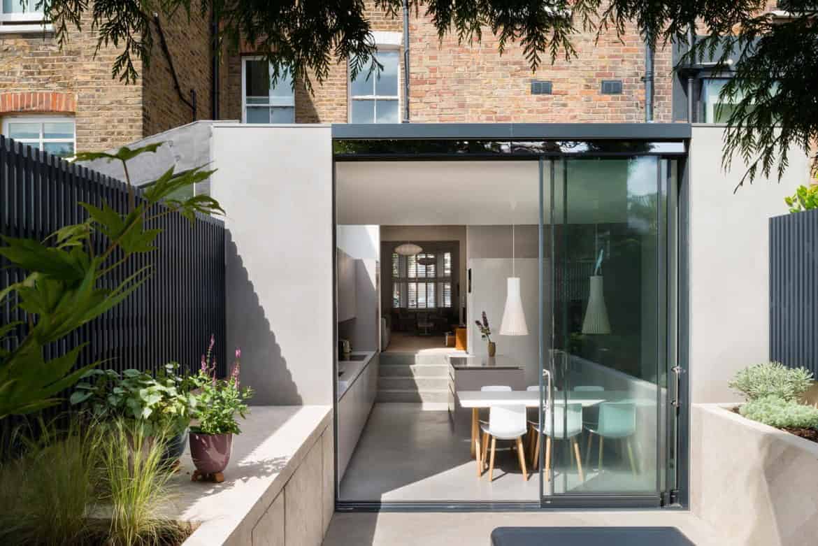 Contemporary modern tiny house with glass sliding door, minimalist interior design, and outdoor garden space for stylish urban living.