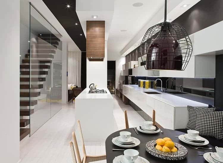 Contemporary modern kitchen design with minimalist white cabinetry, sleek black accents, and stylish lighting for a chic home interior.