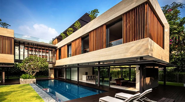 Modern luxury house with wooden and concrete facade, outdoor swimming pool, and stylish outdoor furniture showcasing contemporary architectural design.