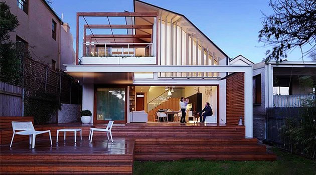 Modern contemporary house with spacious glass windows and wooden deck, showcasing innovative residential architecture and sleek design elements.