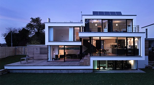 Modern minimalist house with sleek white exterior and expansive glass windows showcasing contemporary architecture design and innovative home interiors.