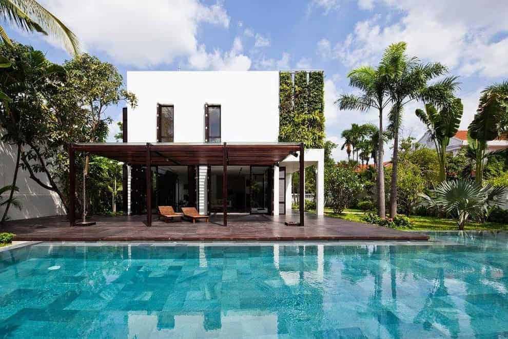 Modern luxury house with a swimming pool, tropical landscaping, and outdoor lounging area, showcasing contemporary architecture and outdoor living design.