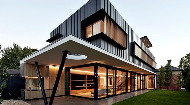 Contemporary modern black and wood facade house with large glass windows, architectural design emphasizing sleek lines, innovative structure, and modern aesthetics.