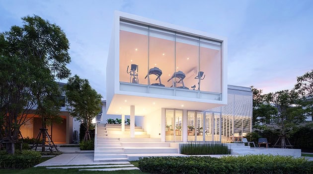 Contemporary modern house with large glass windows, minimalist design, and sleek architectural lines set in a lush garden environment.