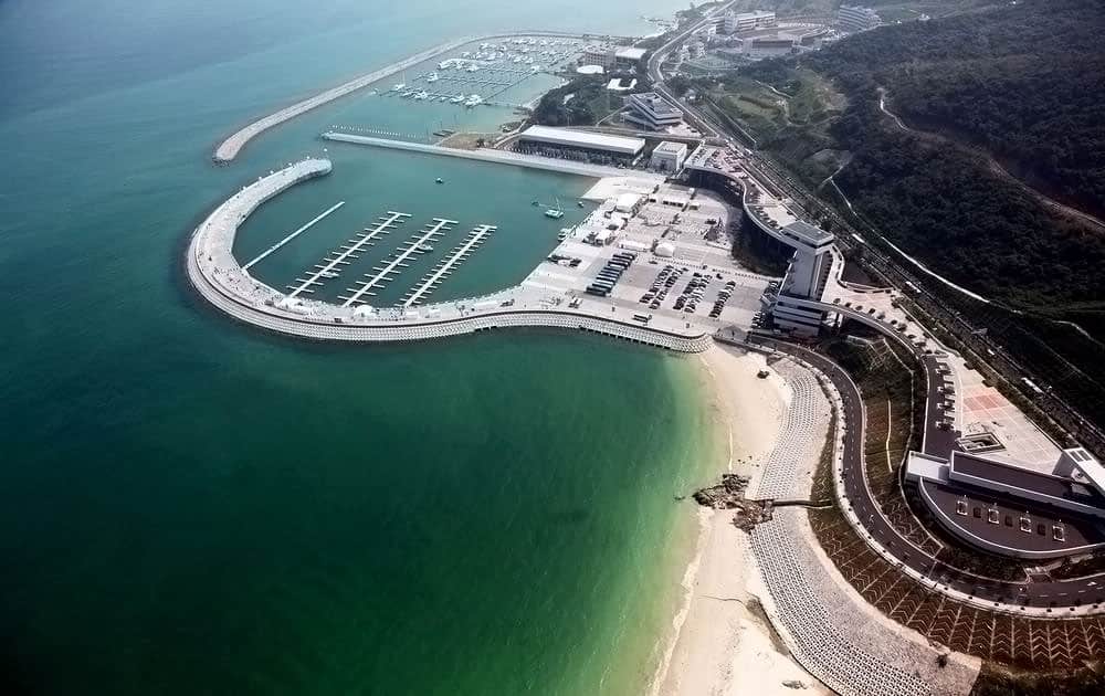 Seaside marina with modern architecture, coastal development, and scenic beach views showcasing innovative design and sustainable construction.