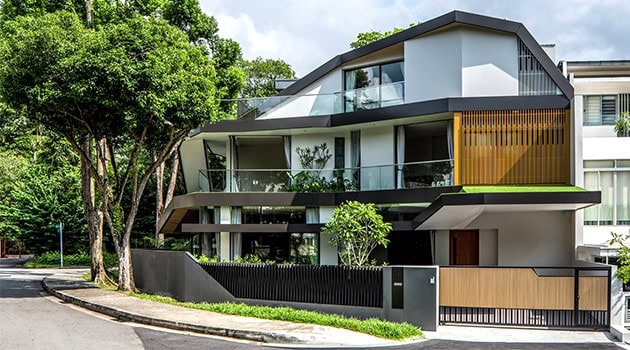 Modern contemporary house with sleek architectural design, large glass windows, and spacious balconies, surrounded by lush greenery for luxury home living.