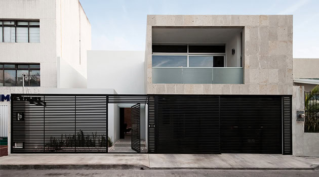 Modern minimalist house with sleek gray concrete facade and black metal gate, showcasing contemporary architecture and innovative design elements.