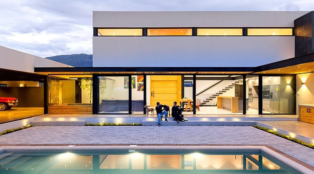 Modern luxury house with sleek architecture, large glass windows, and a swimming pool, showcasing contemporary design elements and innovative residential architecture.