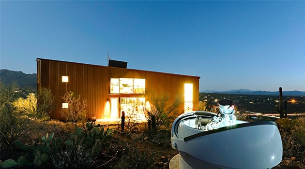 Modern contemporary house with sleek design and large glass windows in desert landscape, showcasing innovative architecture and stylish outdoor living spaces.