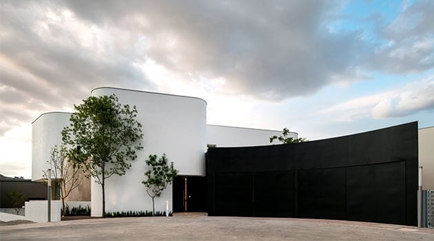 Contemporary modern architectural house with sleek black and white exterior, minimalist design, and landscaping, emphasizing innovative architecture and stylish home design.
