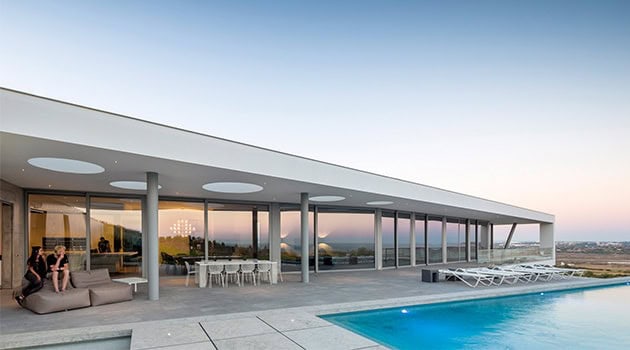 Modern luxury house with a spacious terrace and infinity pool showcasing contemporary architecture, open-plan design, and stunning city views.