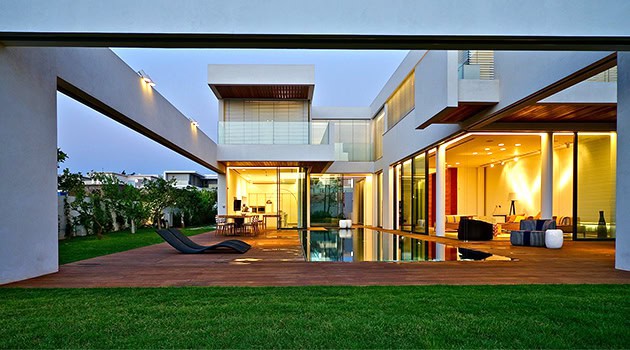 Contemporary luxury house with modern architecture, glass walls, outdoor pool, and spacious deck emphasizing innovative design and stylish living.