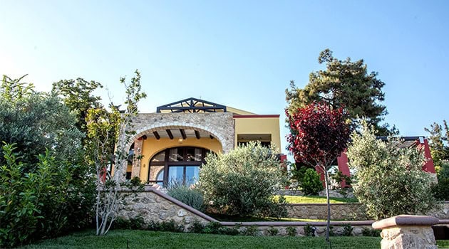 Elegant modern house featuring contemporary architecture with stone accents and lush landscaped garden, perfect example of innovative architecture and garden design.