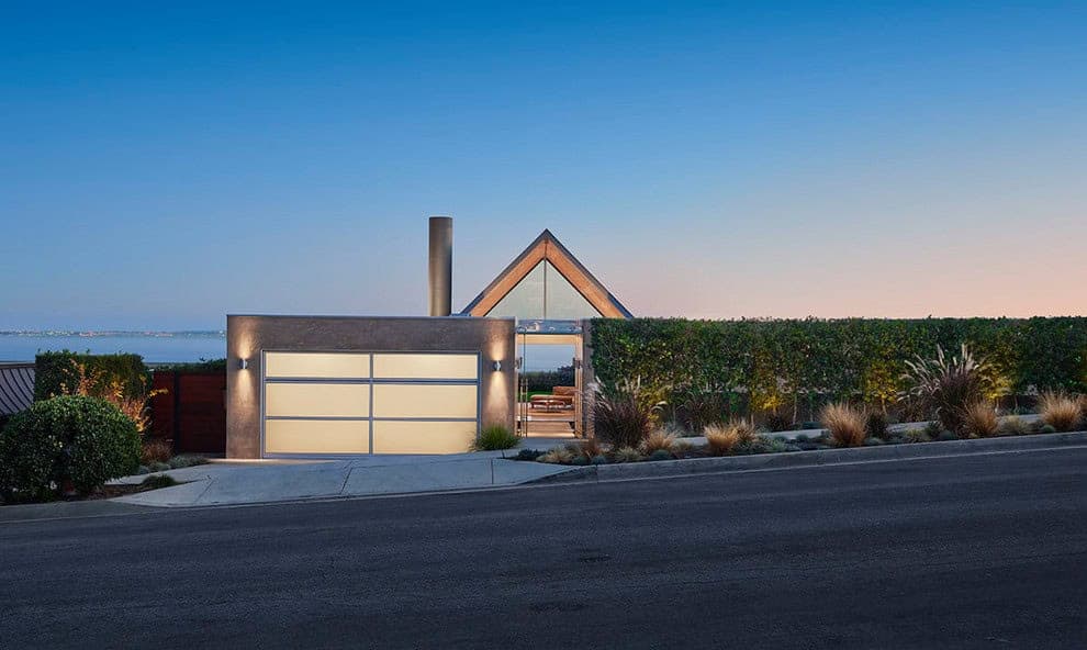 Modern coastal residence with sleek architectural design and eco-friendly landscaping, featuring geometric shapes and a harmonious blend of natural and contemporary materials.