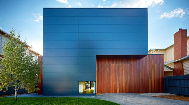 Sleek modern blue and wooden facade of a contemporary minimalist house with clean lines and architectural design elements.