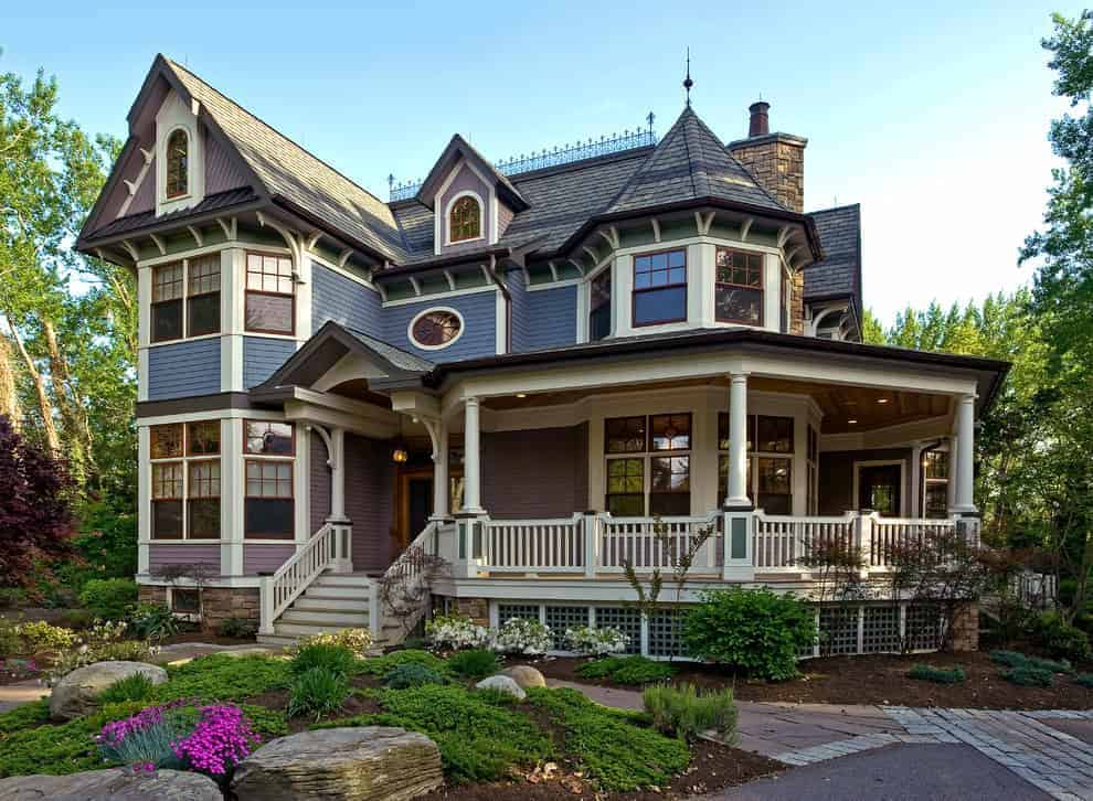 Victorian-style house with intricate architecture, bay windows, and a spacious wrap-around porch surrounded by lush greenery. Elegant design emphasizing historical architectural elements and outdoor landscaping.