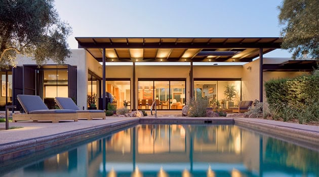 Modern luxury house with a sleek design, large glass windows, and a swimming pool, showcasing contemporary architecture and stylish outdoor living spaces.