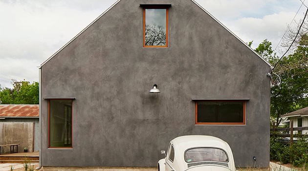 Modern minimalist gray house with geometric design, large windows, and a vintage car parked in front, showcasing contemporary architecture and stylish home exterior design.