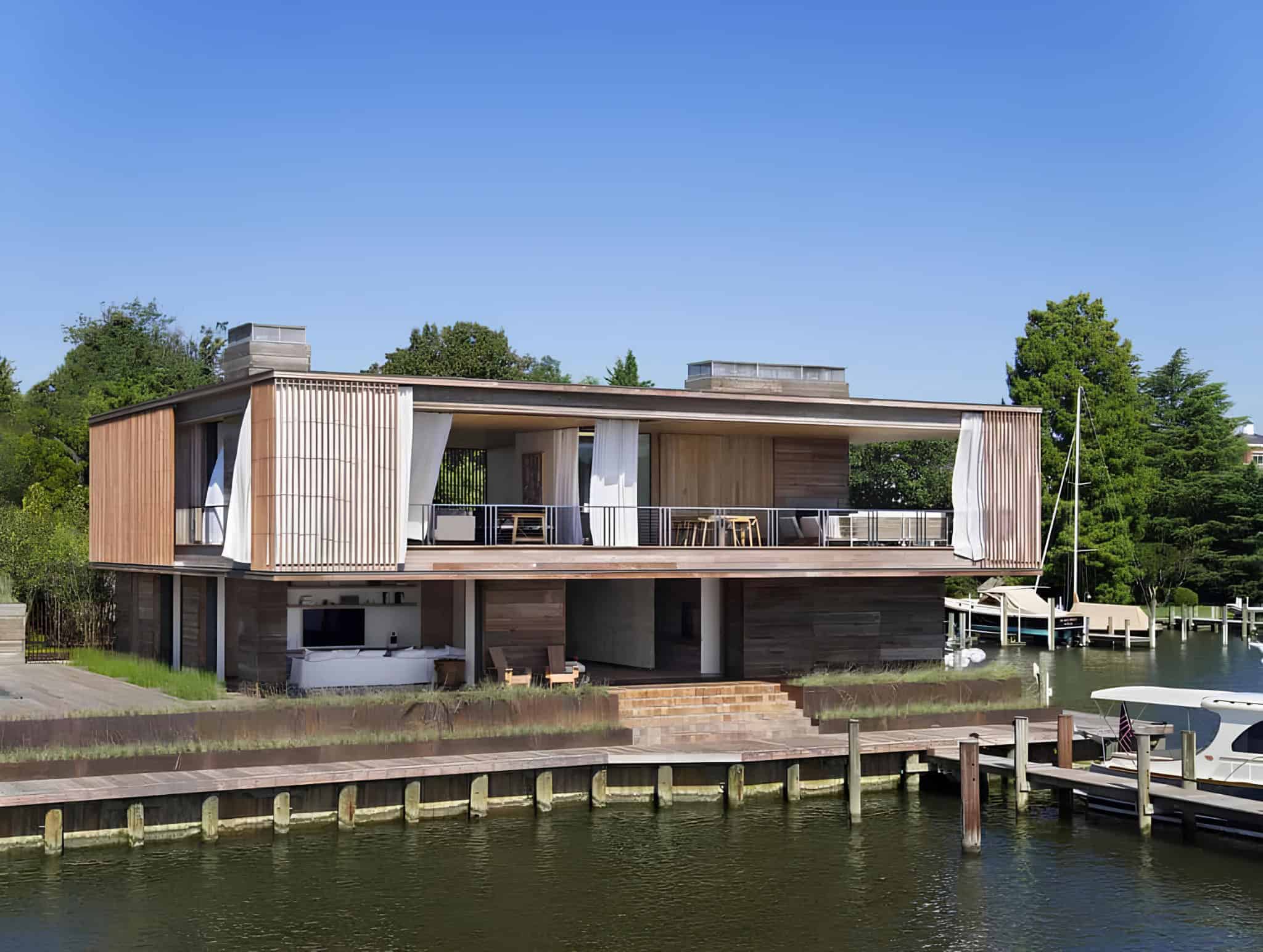 Contemporary waterfront house with modern architecture featuring wood accents, large open terraces, and boat docks, surrounded by lush greenery, ideal for luxury lakefront living.