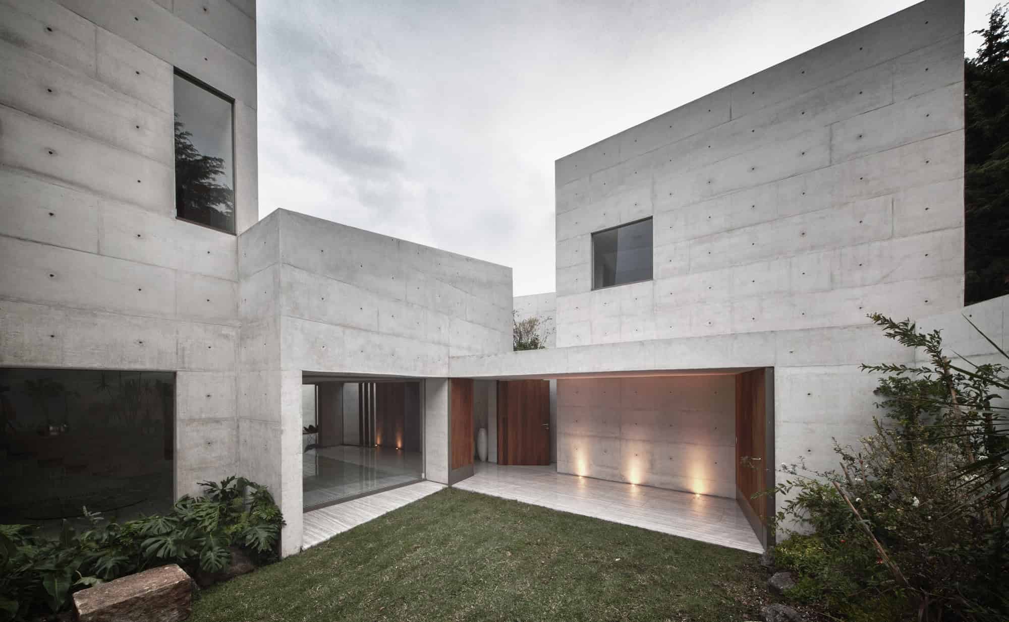 Contemporary modern house with minimalist concrete exterior, large windows, and sleek wooden accents showcasing innovative architecture and design.