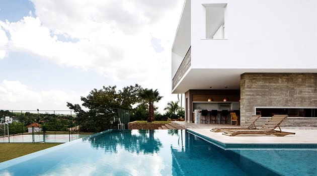 Luxury modern house with infinity pool and outdoor lounging area, contemporary architectural design and sleek exterior finishes.