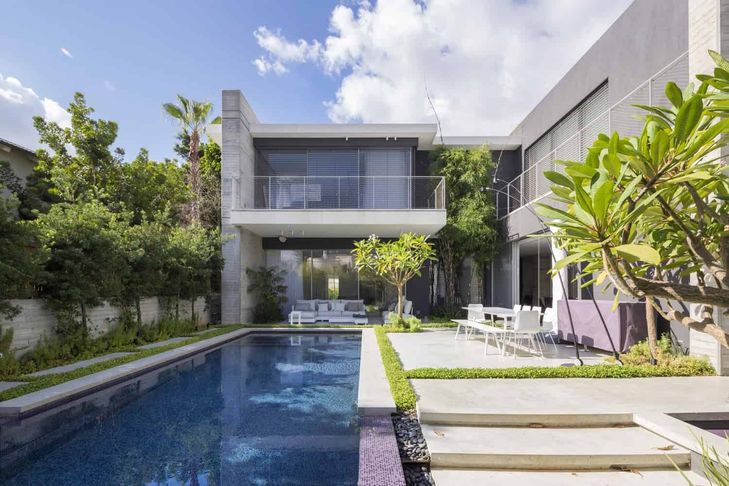 Modern minimalist house with outdoor swimming pool, contemporary architecture and lush landscaped garden, perfect for luxury living and outdoor entertaining.