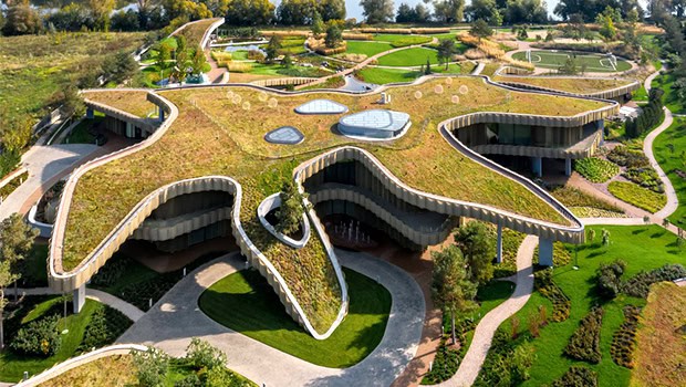 Eco-friendly modern architectural building with green roofs and organic shapes, emphasizing sustainable design and innovative architecture.