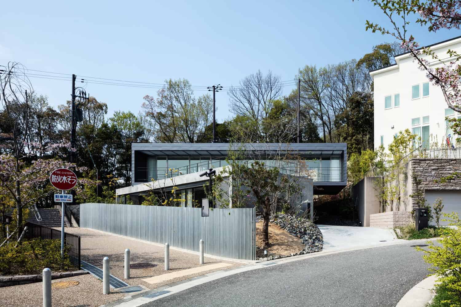 Contemporary modern house design with sleek concrete and glass architecture, surrounded by natural landscaping and urban elements, showcasing innovative architecture art and stylish residential architecture.