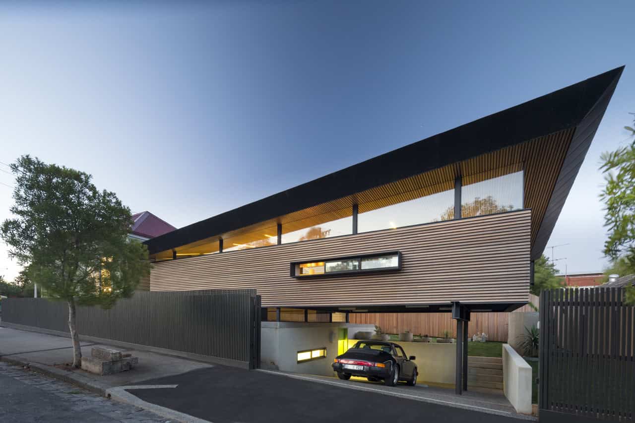 Futuristic modern house with sleek architectural design, wooden exterior, large overhang roof, and innovative use of space, showcasing contemporary residential architecture.