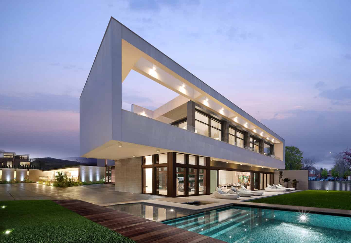Modern minimalist luxury house with sleek white facade, large glass windows, outdoor pool, and contemporary design.