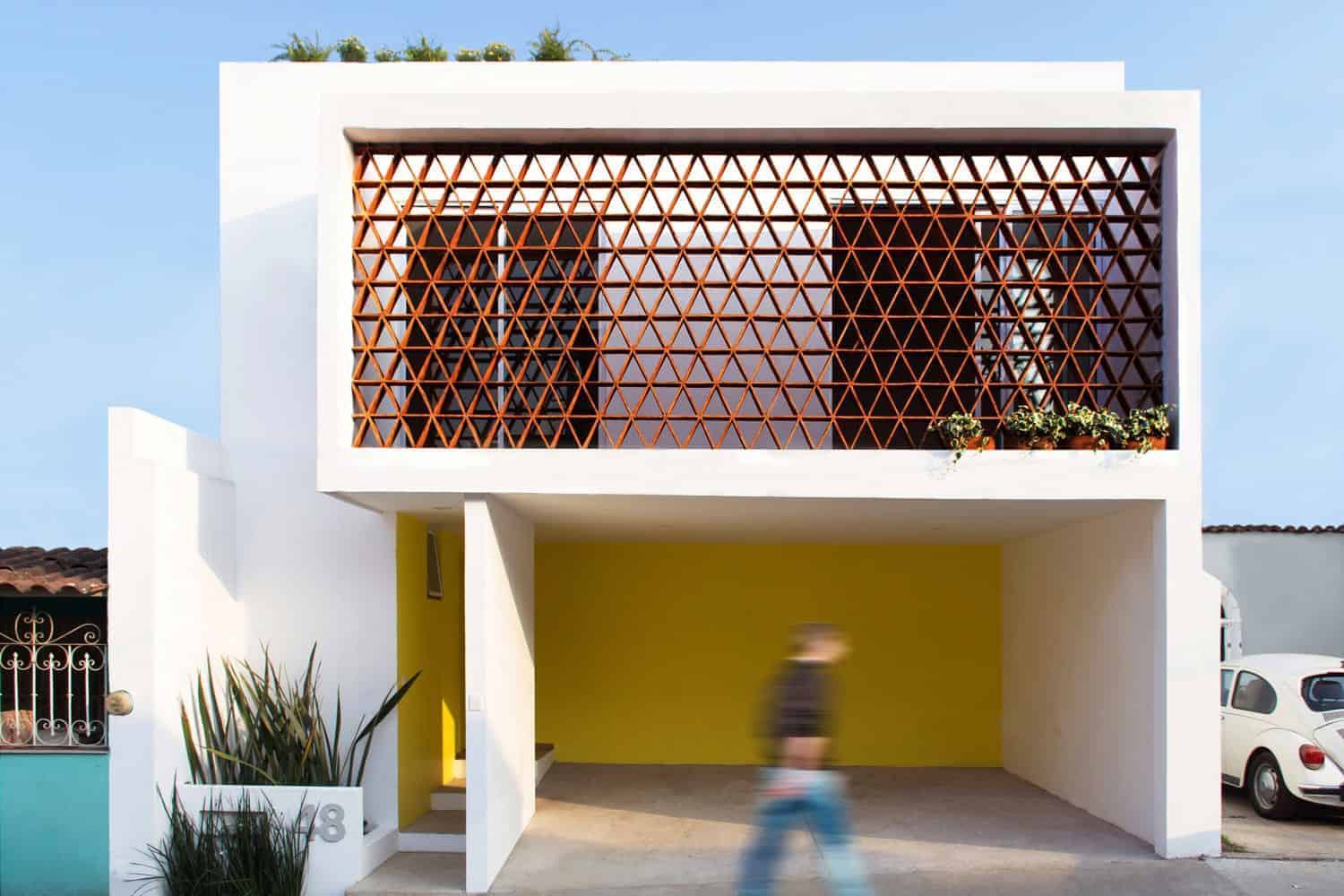 Modern minimalist house with geometric wooden balcony design and vibrant yellow accent wall, showcasing contemporary architectural art and innovative exterior architectural details.