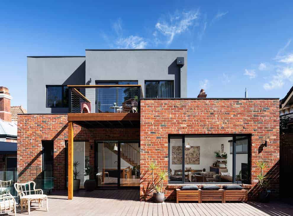 Modern brick residential building with spacious outdoor patio and large glass windows, contemporary architectural design, urban house exterior, innovative home architecture, stylish residential architecture.