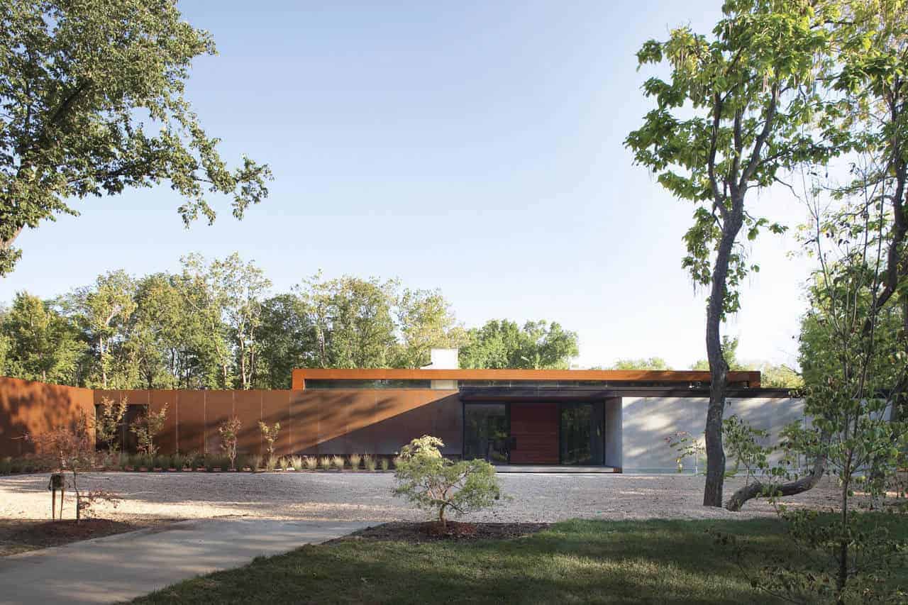 Sleek modern single-story house with minimalist design and clean lines, surrounded by lush greenery and mature trees, featuring a flat roof and contemporary architectural style for outdoor living and comfort, architecture art designs.