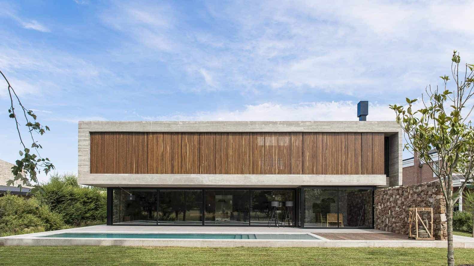 Contemporary modern house with wooden cladding, large glass sliding doors, and minimalist design featuring clean lines and outdoor pool area.