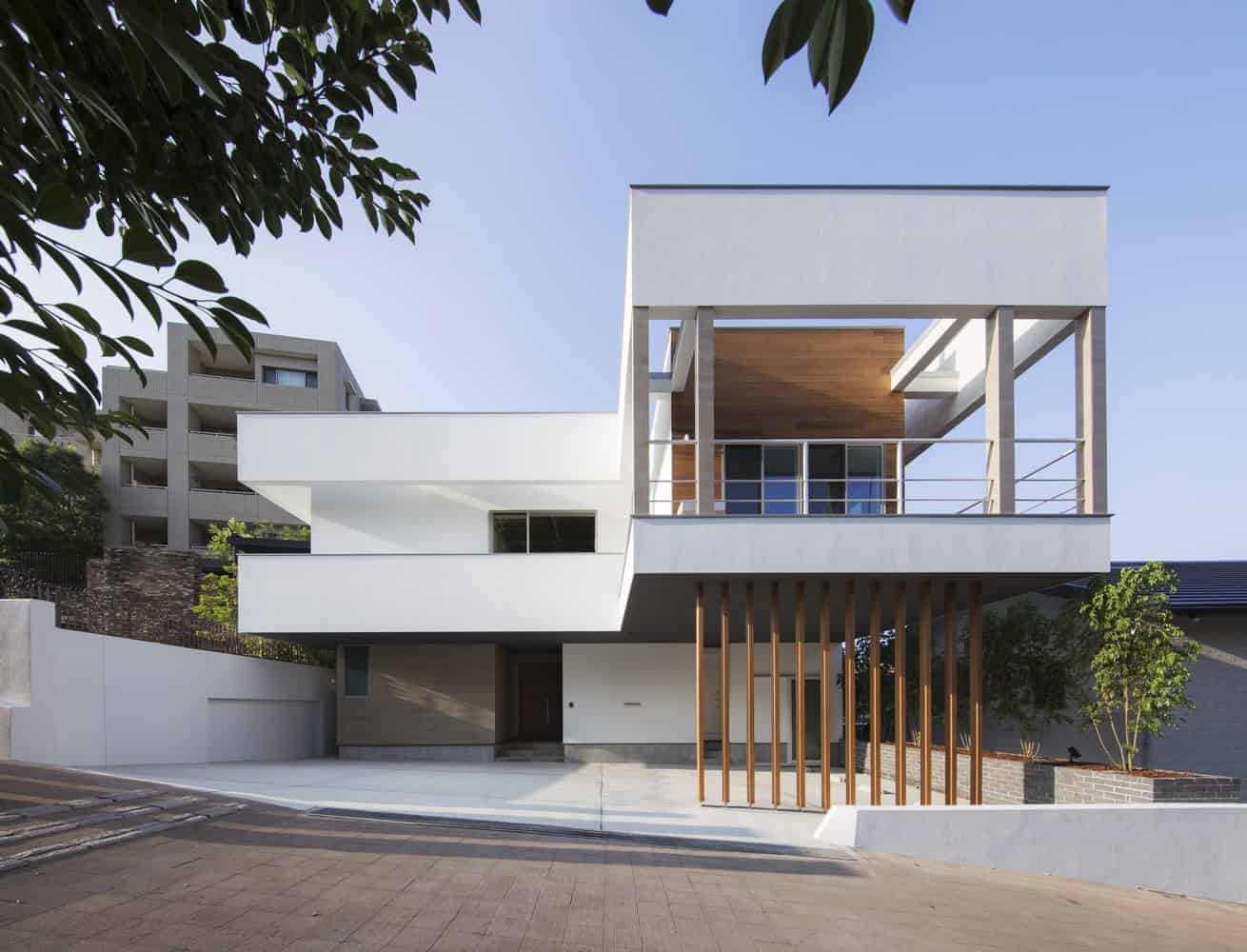 Contemporary modern house design with sleek white exterior and large balcony, showcasing minimalist architecture, wood accents, and clean lines in an urban residential setting.