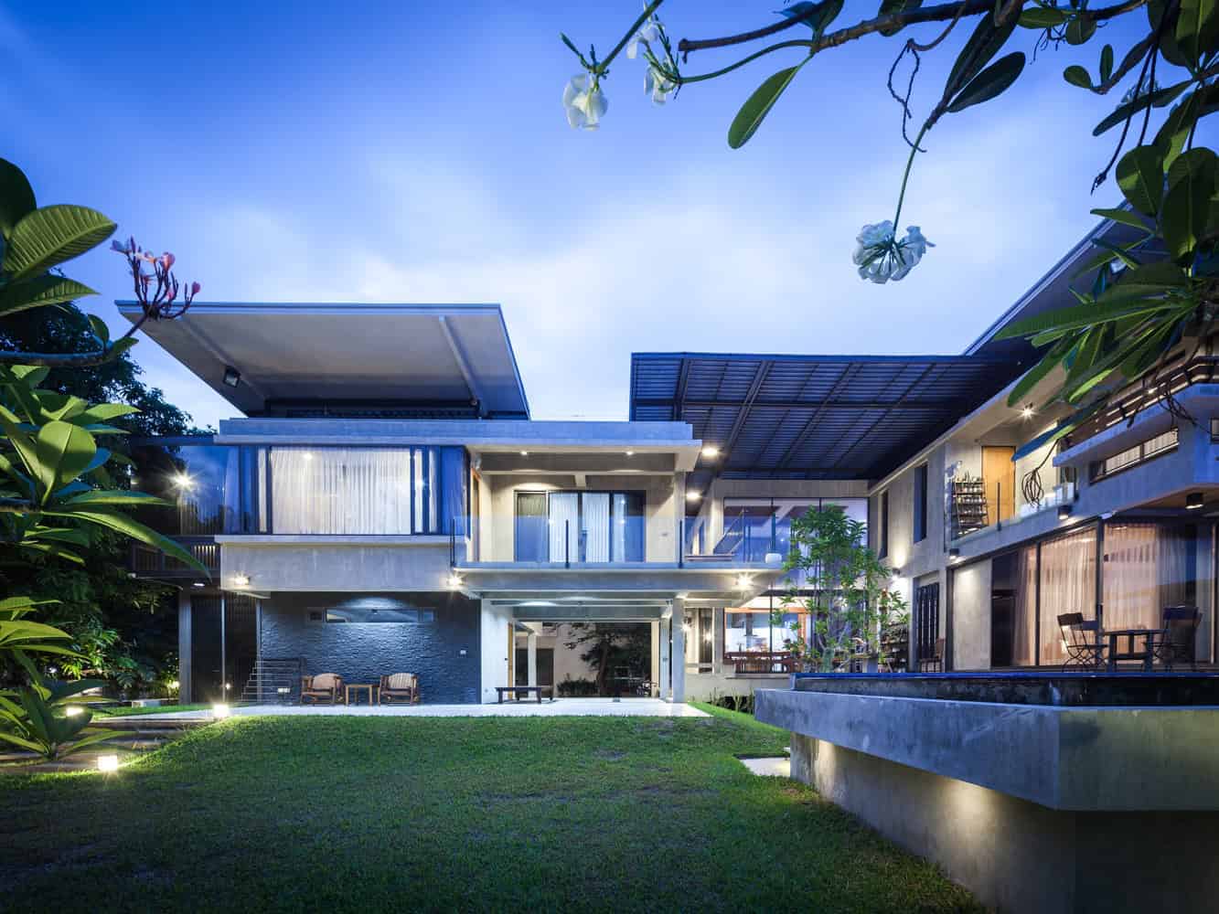 Sleek modern house with contemporary architecture, featuring clean lines, large glass windows, and a landscaped garden at dusk. Perfect blend of luxury and innovative design.