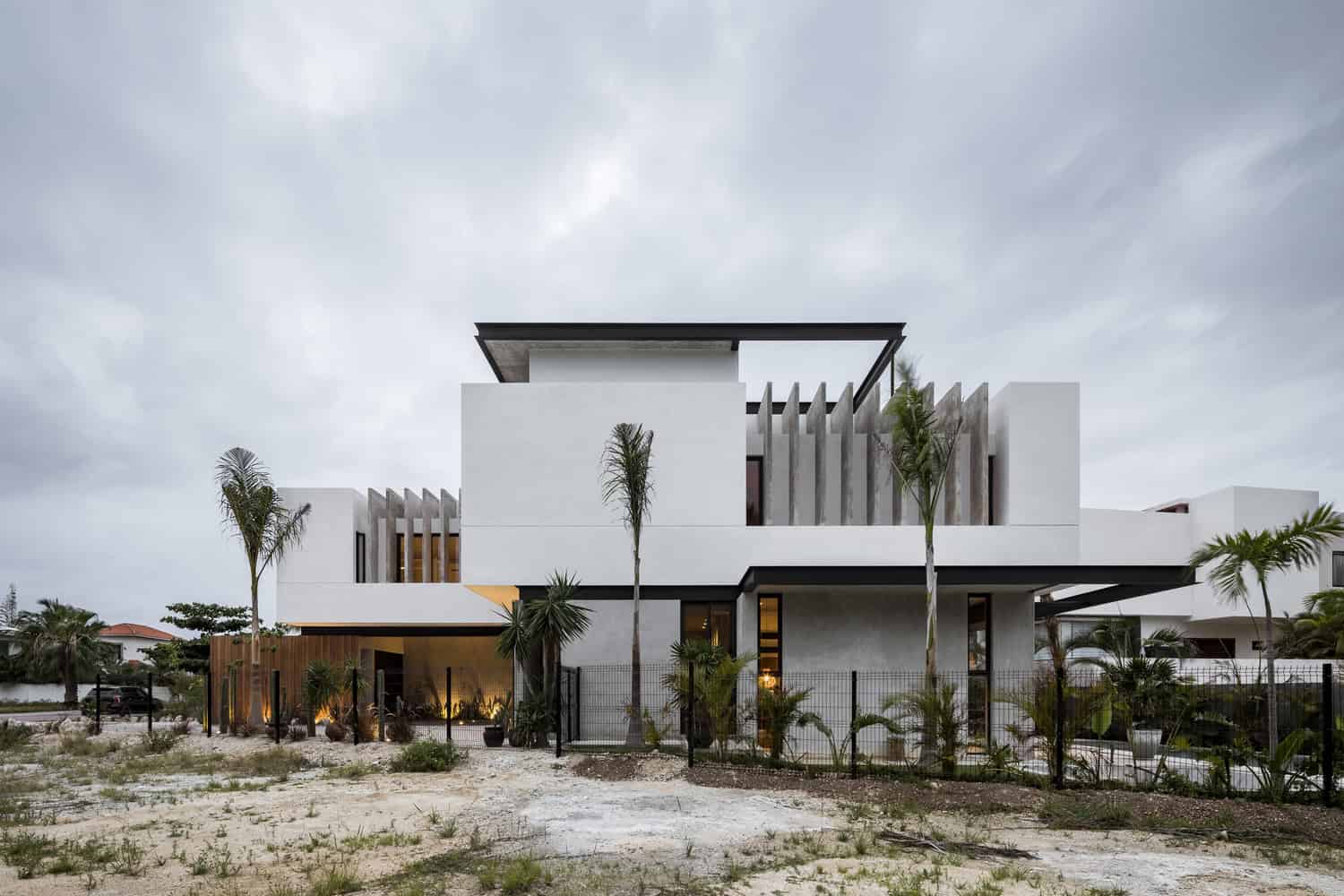 Contemporary modern white house design with minimalist architecture, clean lines, and tropical landscaping, showcasing innovative residential architecture with focus on aesthetics and functionality.