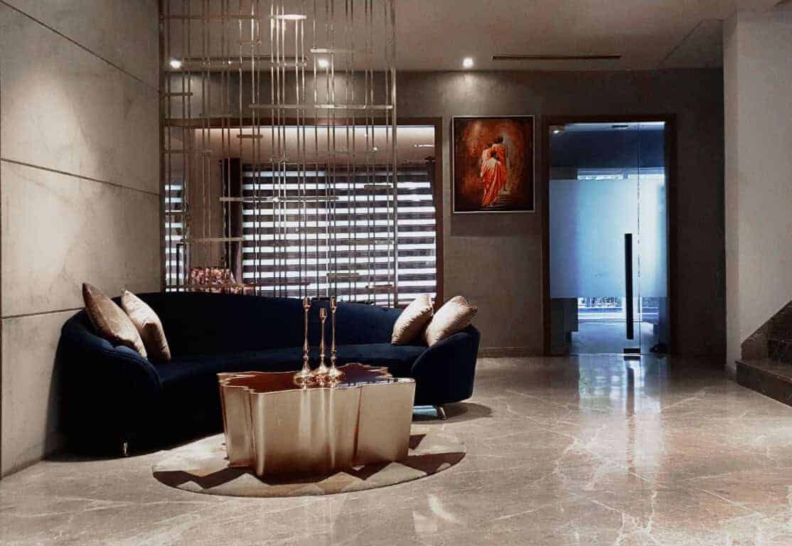 Luxurious modern living room interior with velvet navy sofa, contemporary metallic coffee table, elegant wall art, and stylish window blinds, showcasing upscale architecture art designs and interior decor.