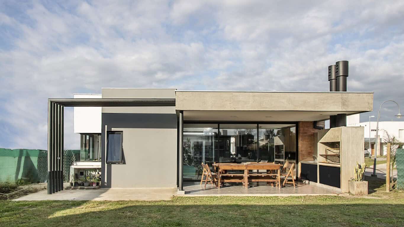 Modern minimalist house with sleek concrete and glass design, outdoor dining area, contemporary architecture, stylish outdoor living space, innovative home design, architectural art, and urban residential architecture.