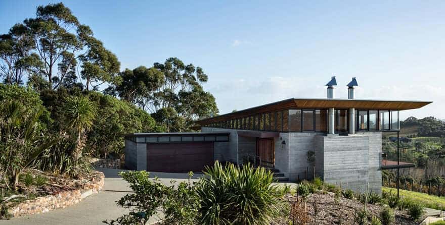 Modern contemporary house with sleek design, large glass windows, and eco-friendly features set in lush natural landscape, showcasing innovative architecture and stylish outdoor environment.
