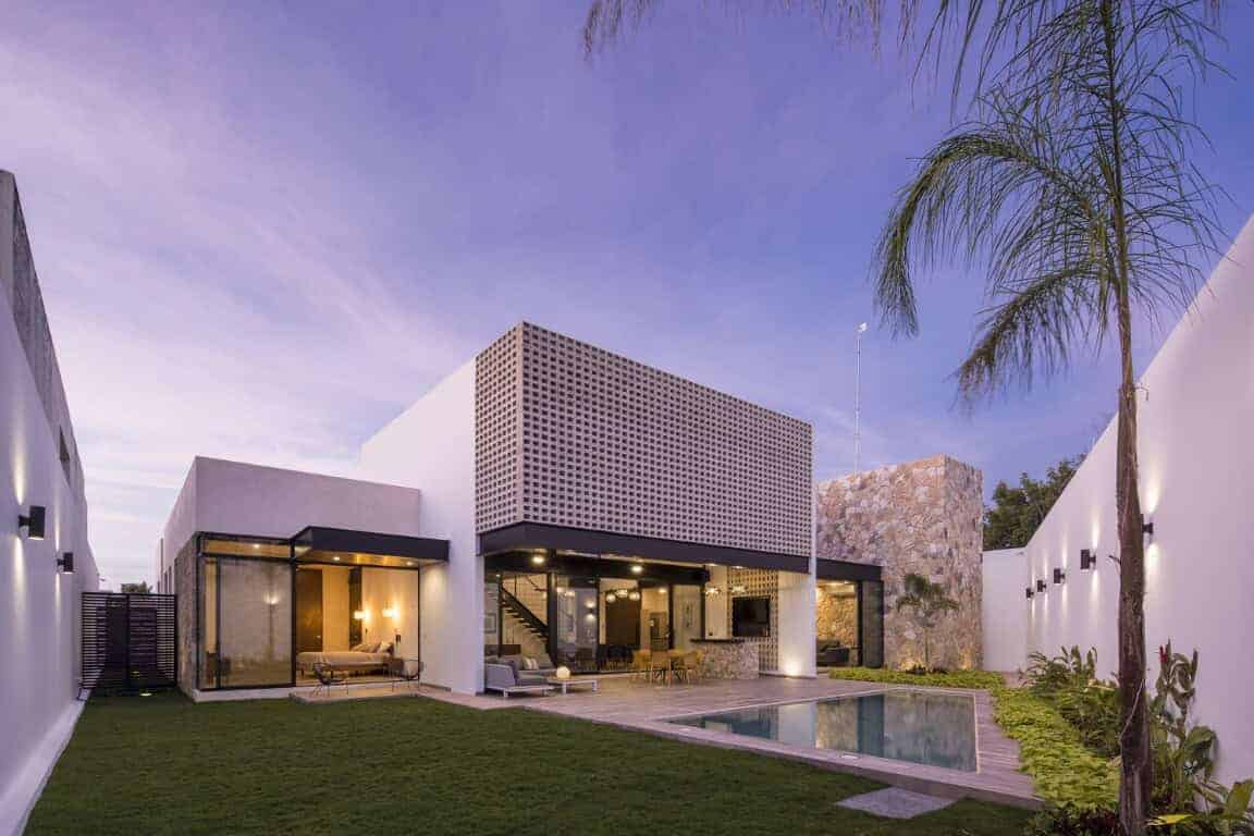 Modern minimalist house with sleek white exterior, large glass windows, outdoor pool, lush garden, and contemporary design elements, perfect for upscale architecture and luxury home inspiration.