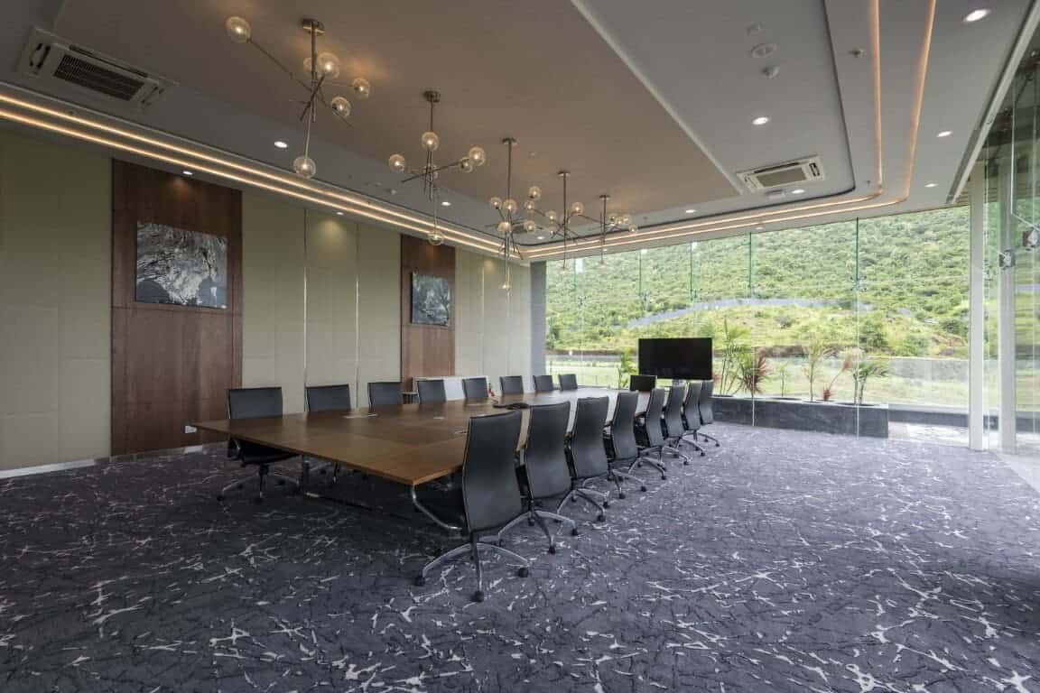 Modern conference room with large glass windows, stylish lighting fixtures, and a scenic mountain view, perfect for corporate meetings and business events.