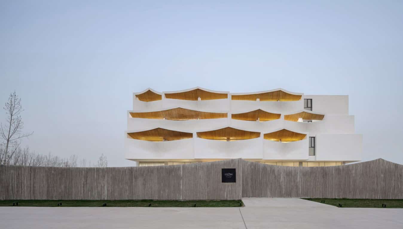 Futuristic modern architectural building with unique layered wooden balconies and white facade, showcasing innovative design and sustainable construction techniques.