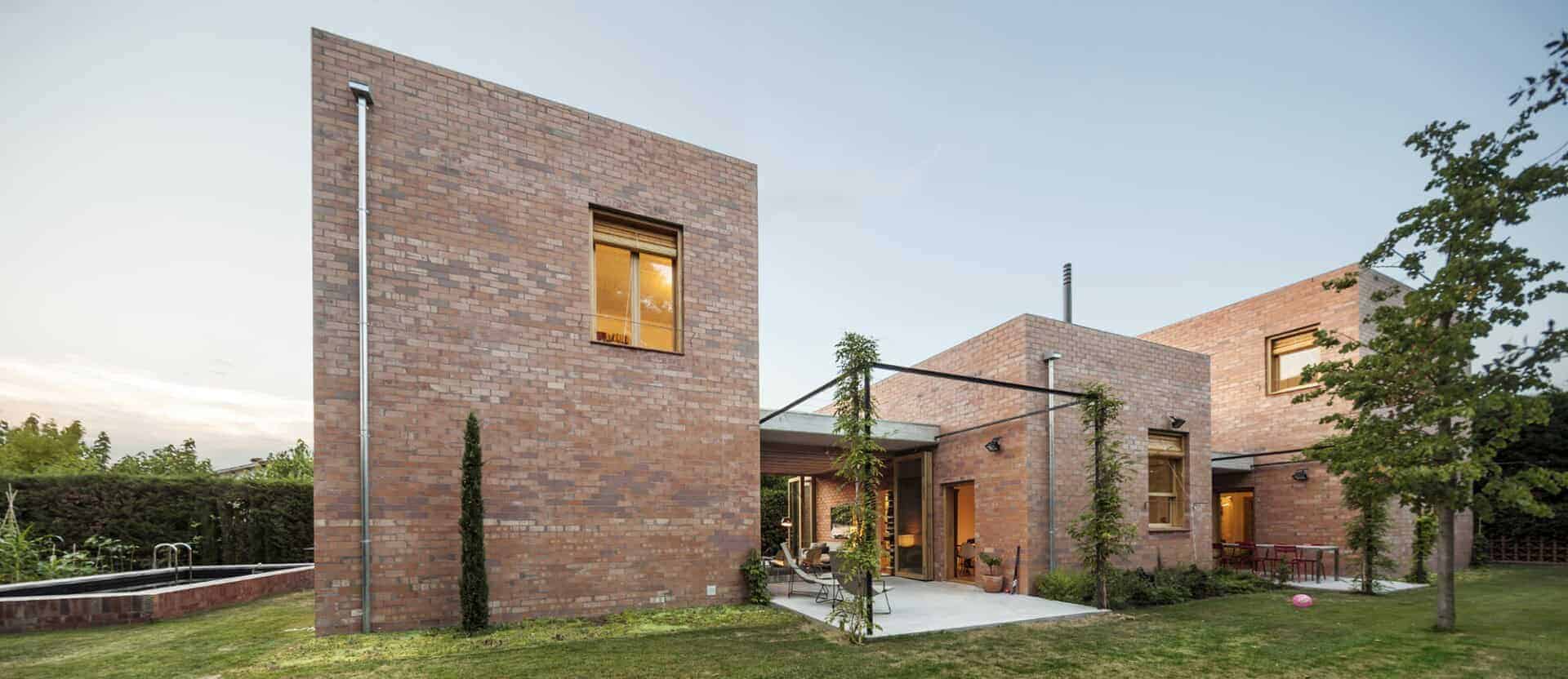 Contemporary brick house with modern architecture and lush backyard garden.
