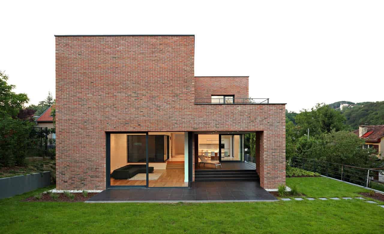 Contemporary brick house with modern architecture design, large glass sliding doors, and a spacious backyard, showcasing stylish residential architecture.