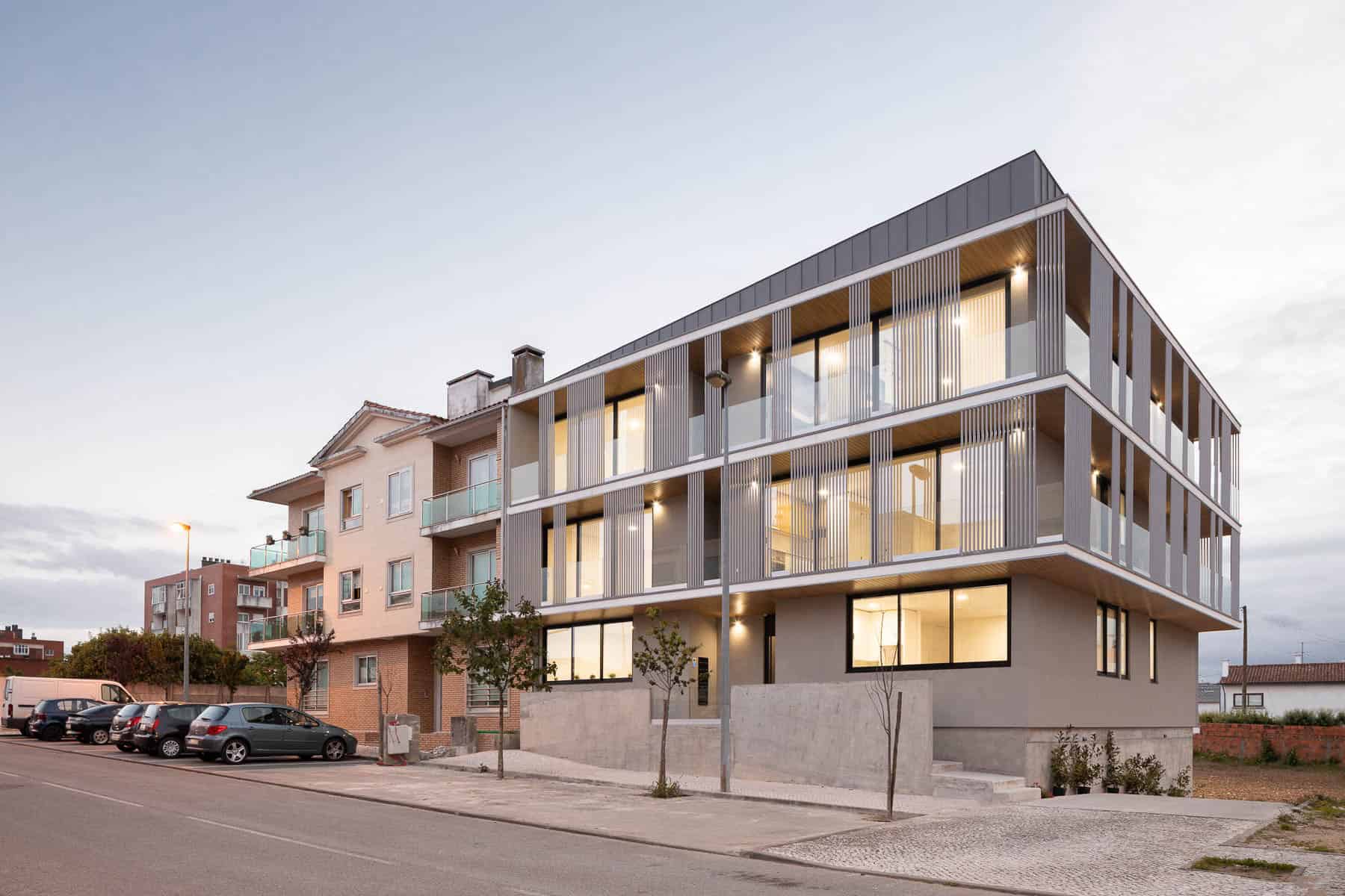 Contemporary multi-story residential building with modern architectural design featuring extensive use of glass and metal elements, creating a sleek and stylish urban living space.